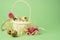 White wicker basket filled with straw,small pink roses,quail eggs on a green background. The concept of Easter Holidays. Easter