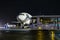 White wide-body passenger airplane and airport shuttle bus on the night apron. Aircraft ground handling