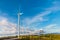 White wind turbine for alternative energy in day with blue sky background, electric clean power concept