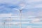 White wind turbines generating electricity alternative renewable energy from nature in wind power station