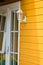 White window and antique lantern on yellow cottage