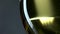 White wine being poured into a wineglass, grey, closeup, slowmotion