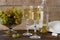 White wine with glass goblets and grape bunches on a wooden background.