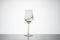 white wine movement inside a crystal glass. white wine glass on white background with reflection on the base. image for