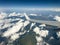 White wing from airplane window with mountain range below on sunny day. Great views of desert landscape and snowed peaks from