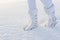 White winter boots on deep snow background.