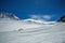 White winter mountains covered with snow in blue cloudy sky. Mountain skiers ride the slope. Alps. Austria. Pitztaler