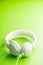 White wired stereo headphones on green background