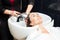 White woman getting a hair wash in a beauty salon