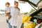 White woman holding her son while getting shopping bag out of trunk