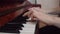 White woman playing piano hands close up. In slow motion, the fingers move through the piano keys while practicing