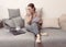 White woman sitting on couch with document and with fright looks at laptop