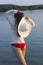 White woman in sun hat posture on beach lake