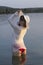 White woman in sun hat posture on beach lake