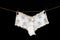 White women`s thong panties on a clothesline fastened with white pegs