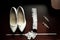 White women`s wedding shoes, garter, earrings on a dark wooden background