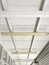 White wooden beam ceiling perspective with old ceiling lighting system in Caribbean construction. Tropical industrial architecture