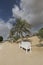 White wooden bench next to the road in a desert