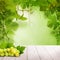 White wooden board with grape on blurred green grapevine