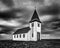 White wooden church with storm clouds