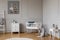 White wooden cradle with emerald pillow and toys in the corner of stylish scandinavian baby bedroom interior, real photo with copy