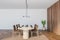 White wooden dining room with brown chairs and oval table, white wall