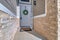 White wooden front door of house with security lockbox and green wreath decor