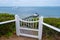 White wooden gate leading to pier.