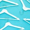 White wooden hangers on blue background