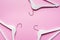 White wooden hangers on pastel pink background. Fashion feminine blog sale store promo design shopping concept. Flat lay