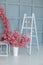 White wooden ladder and garland of eggs. Easter decoration concept. Decorative ladder and vase with branches of blossoming sakura