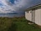 White wooden shed with door and meadow on the shore of Andfjord on AndÃ¸ya island near village Dverberg, VesterÃ¥len, Norway.