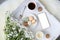 White wooden tray with black tea, coffee, plate with macaroon cakes, flowers, candles, blank screen phone, concept of technology,