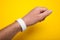 White wristband, bracelet mockup for event on yellow background