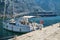 White yacht moored at the pier on the waterfront. Huge passenger liner ship is can be seen in the background