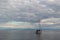 white yacht with people floats in silver clear lake baikal, in the morning, background of blue mountains on the horizon