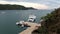 White yacht with people stands near the pier in the bay.