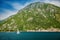 White yacht sailing along historic town of Perast at famous Bay of Kotor