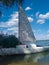 White yacht with sails on the river bank