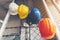 White, yellow, blue and orange helmets that hang on the iron fence at the construction site