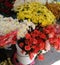 White and yellow chrysanthemums and pink roses on display at a flower shop