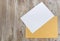 White and yellow envelopes on a wooden background. Copy of space. Place for text. View from above.