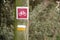 White and yellow Marked on a small PR trail log next to a sign indicating a bicycle route