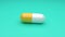 White-Yellow pills isolated rotating on green background. Seamless looping.