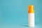 White and yellow sunscreen bottle with cream or lotion on the aqua blue background with copy space. Empty bottle mockup. Spf sun