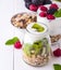 White yogurt with muesli in glass bowl with pieces of kiwi on to