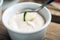 White yogurt sauce with lime in small bowl for traditional meze dinner on the wooden table in restaurant