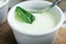 White yogurt sauce with mint in small whire bowl for traditional meze dinner on the wooden table in restaurant