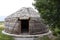 White yurt with an open entrance next to a tree