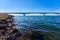 White Zeeland bridge in Holland, blue sea water and sky, sea algae in the foreground. Netherlands